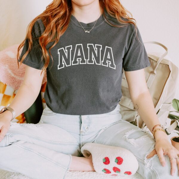 Comfort Colors Pepper embroidered Nana T-Shirt with large white block letters, styled with casual outfit.