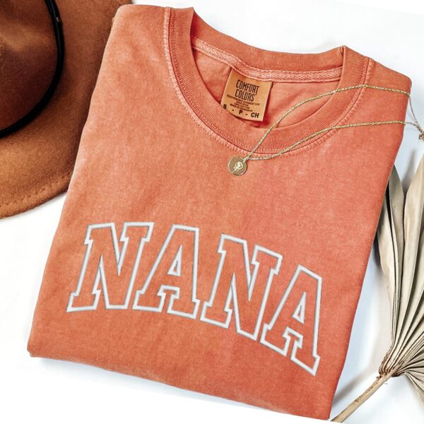 Comfort Colors Yam Nana T-Shirt in burnt orange with white varsity letters.