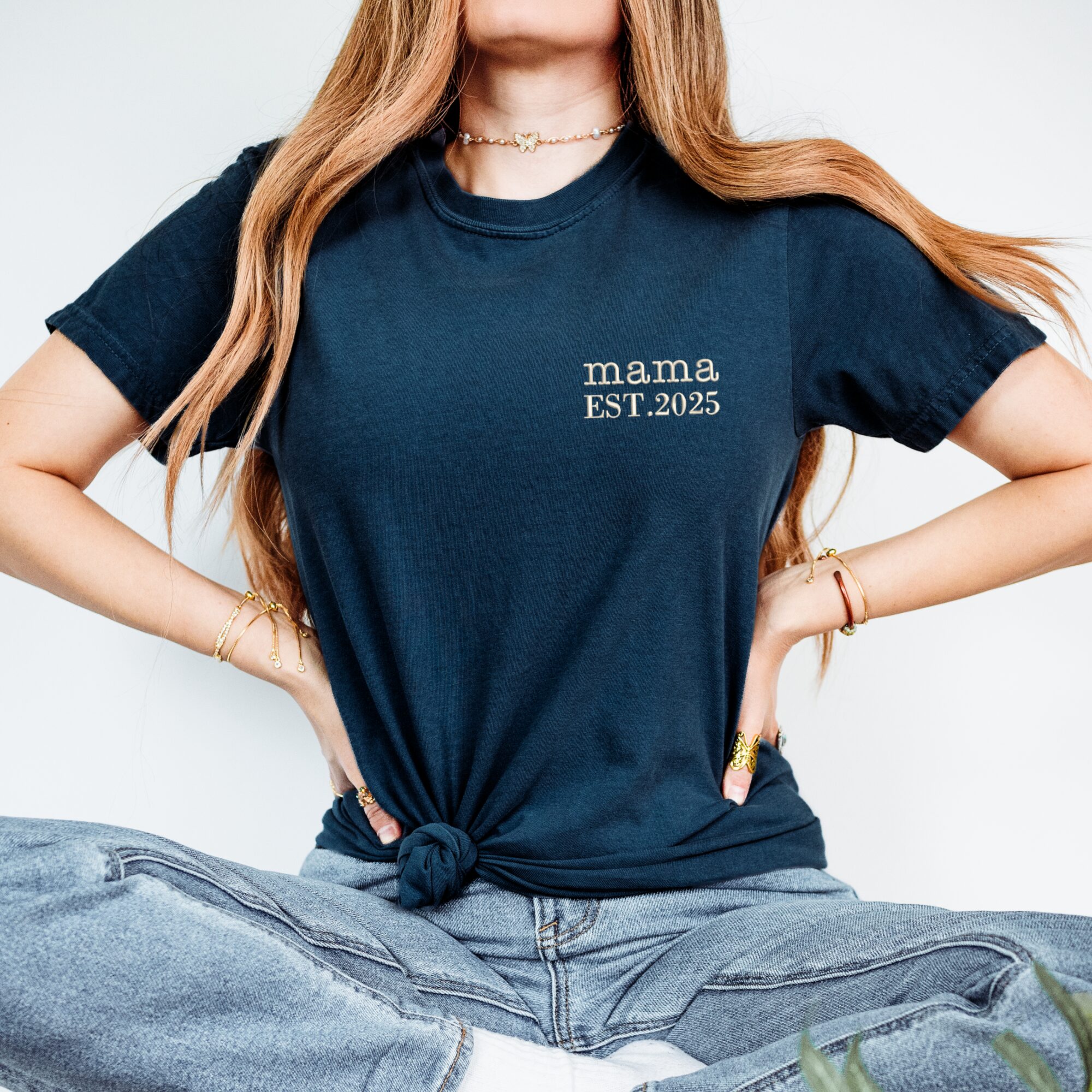 Blue Jean Comfort Colors Embroidered Mama Shirt worn by woman, knotted front, white 'mama EST. 2025'.