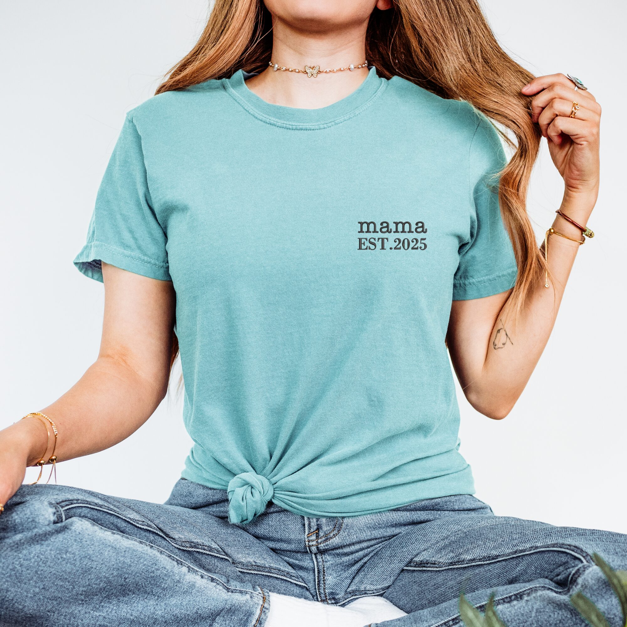 Seafoam green Comfort Colors Mama Shirt worn by woman, knotted front, black 'mama EST. 2025' embroidery.