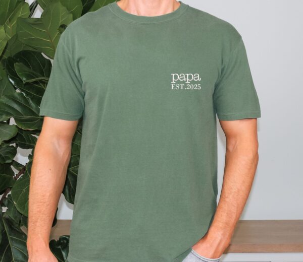 Moss green Comfort Colors Papa Shirt worn by man, white “papa EST. 2025” embroidery detail on chest.